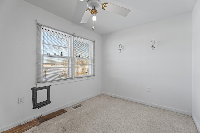 carpeted spare room featuring ceiling fan