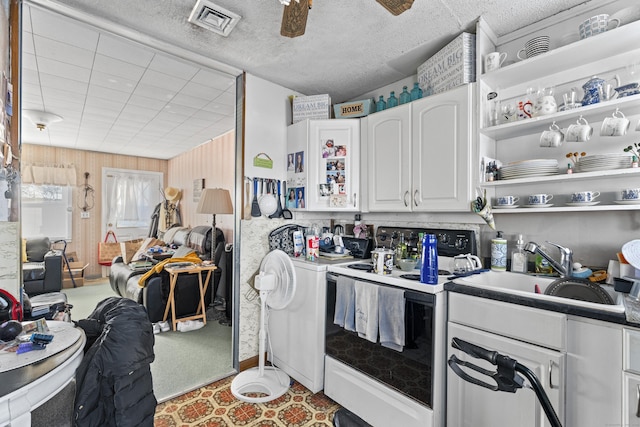 kitchen featuring washer / dryer, sink, white cabinetry, electric range, and ceiling fan