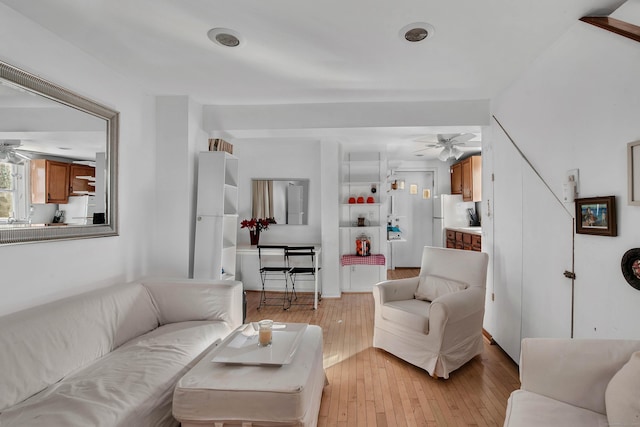 living room with ceiling fan and light wood-type flooring