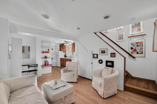 living room with ceiling fan and light wood-type flooring