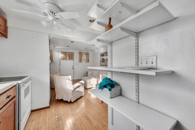 kitchen featuring ceiling fan, light wood-type flooring, and white range with electric stovetop