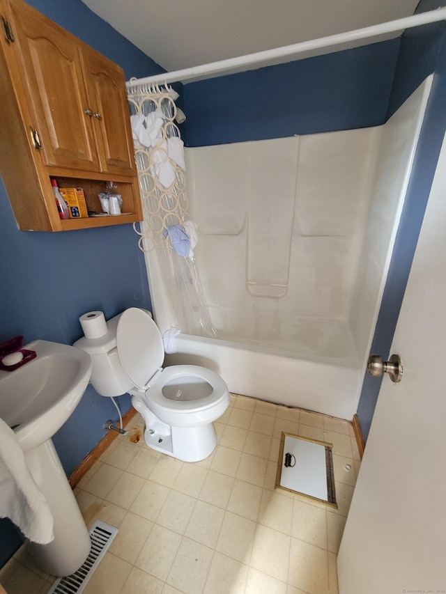 bathroom with shower / tub combo with curtain, tile patterned floors, and toilet