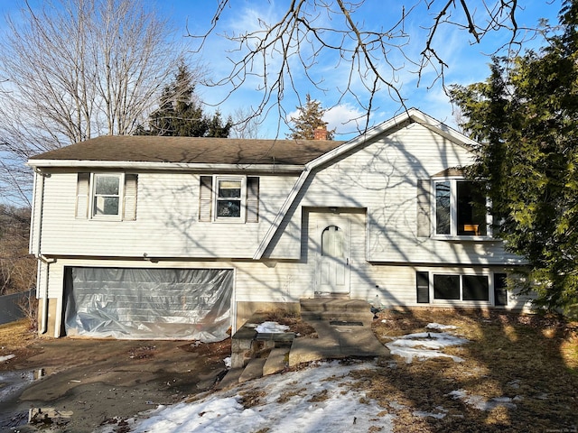 view of front of house featuring a chimney, an attached garage, and a gambrel roof