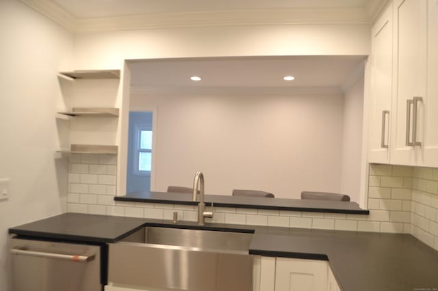 kitchen featuring ornamental molding, sink, stainless steel dishwasher, and white cabinets