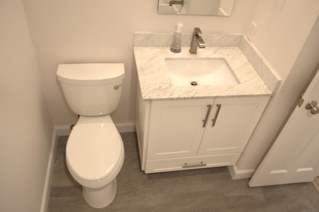 bathroom featuring vanity, tile patterned floors, and toilet