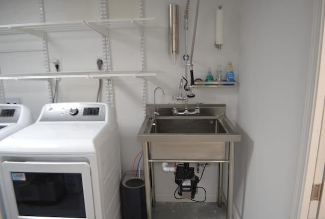 clothes washing area with sink and washer and dryer