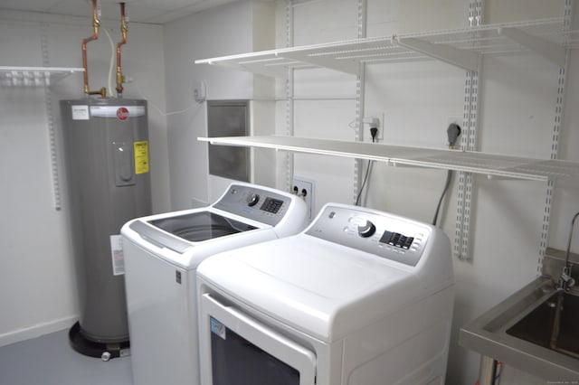 clothes washing area featuring sink, electric water heater, and washer and dryer