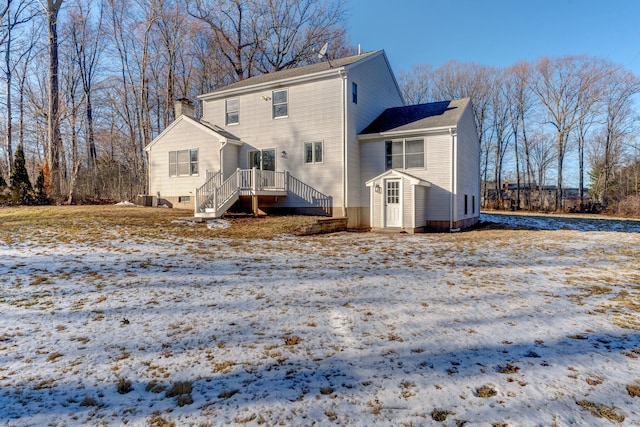 view of snow covered back of property