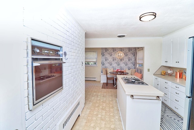 kitchen featuring white cabinets, a baseboard radiator, stainless steel gas cooktop, and oven