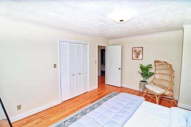 bedroom with crown molding, hardwood / wood-style flooring, a closet, and a textured ceiling