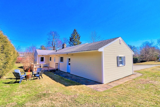 back of property featuring a lawn and a fire pit