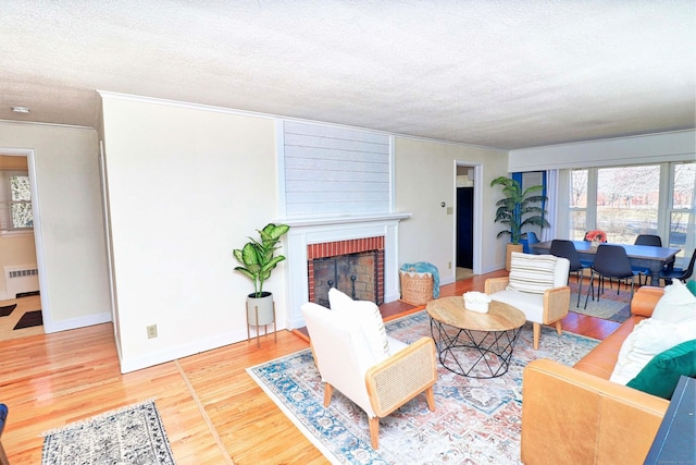 living room with hardwood / wood-style flooring, radiator, a textured ceiling, and a fireplace