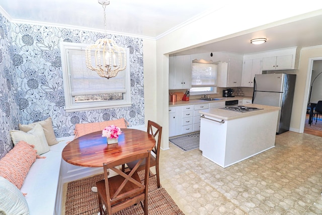 kitchen featuring pendant lighting, white cabinetry, sink, stainless steel appliances, and crown molding