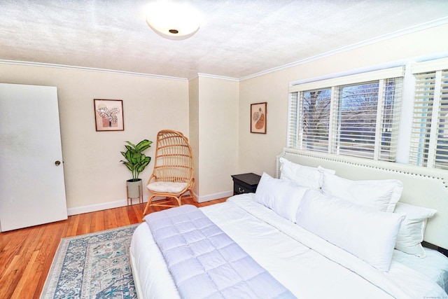 bedroom with crown molding, hardwood / wood-style floors, and a textured ceiling