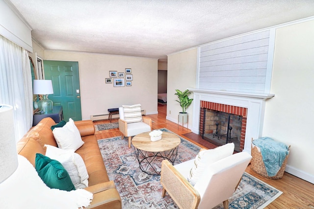 living room featuring wood-type flooring, a textured ceiling, a fireplace, and baseboard heating