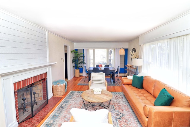 living room featuring hardwood / wood-style flooring and a brick fireplace