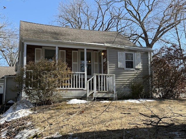 view of front of property featuring a shingled roof and a porch