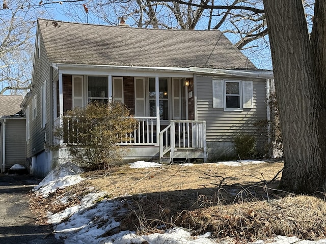 view of front of house with a shingled roof and covered porch