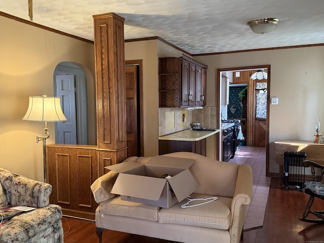 living room with dark wood-style floors and ornamental molding