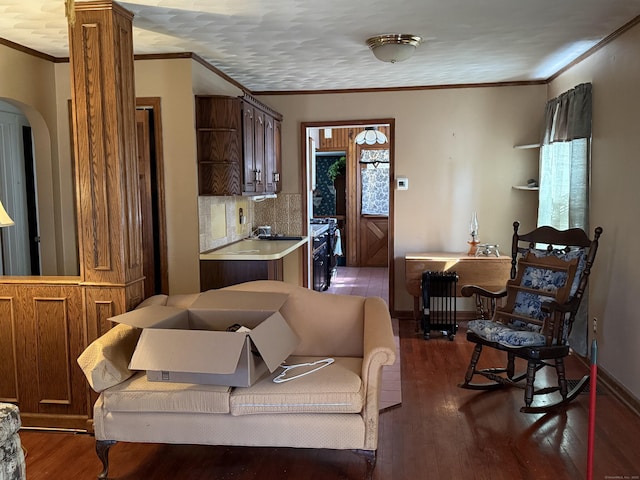 kitchen featuring tasteful backsplash, light countertops, ornamental molding, dark wood-type flooring, and baseboards