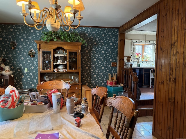 dining space featuring a chandelier, tile patterned floors, ornamental molding, and wallpapered walls