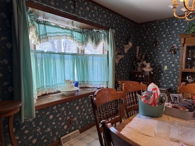 dining space with ornamental molding, visible vents, an inviting chandelier, and wallpapered walls