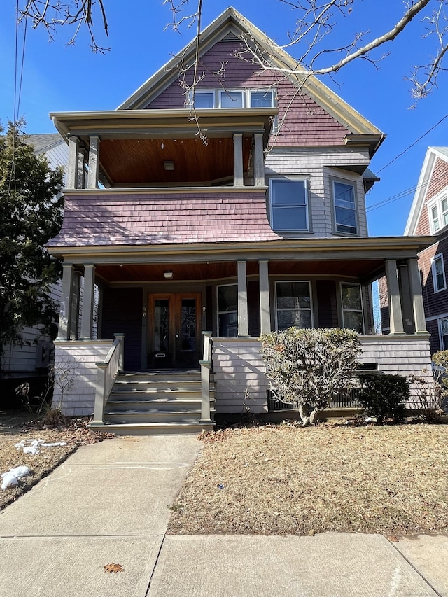 victorian house featuring covered porch and a balcony