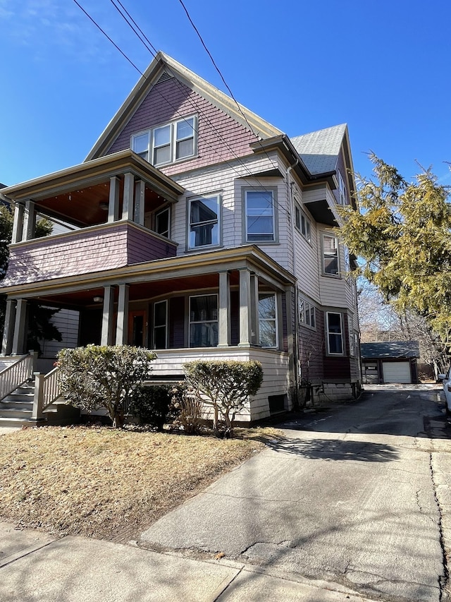 exterior space featuring a balcony, a porch, and an outbuilding