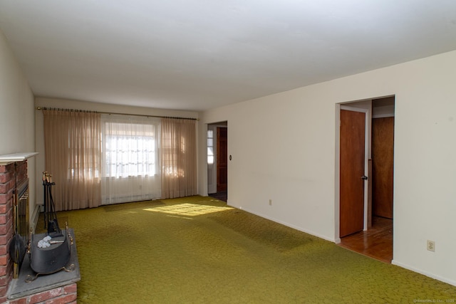 unfurnished living room featuring carpet floors, a fireplace, and baseboards