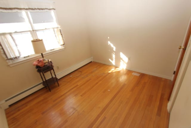 unfurnished room with light wood finished floors and baseboards