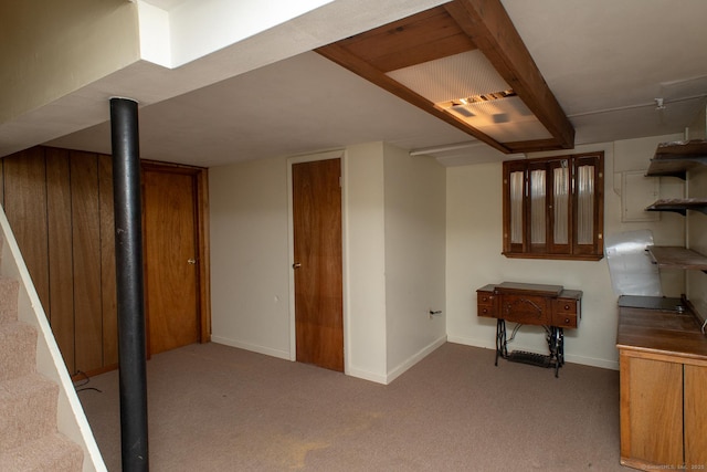 finished below grade area featuring baseboards and light colored carpet