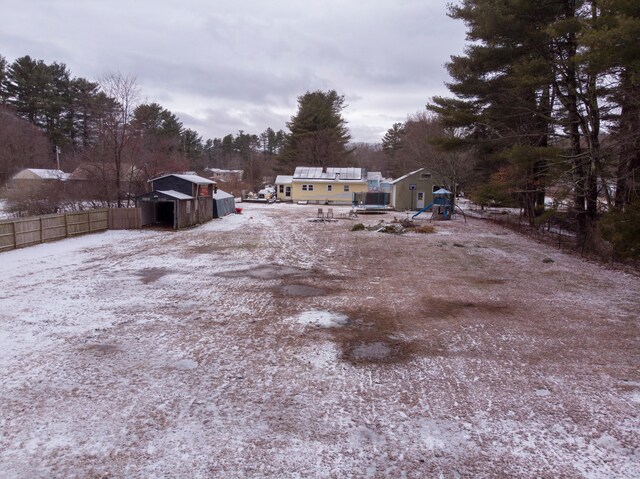 yard covered in snow featuring a storage unit