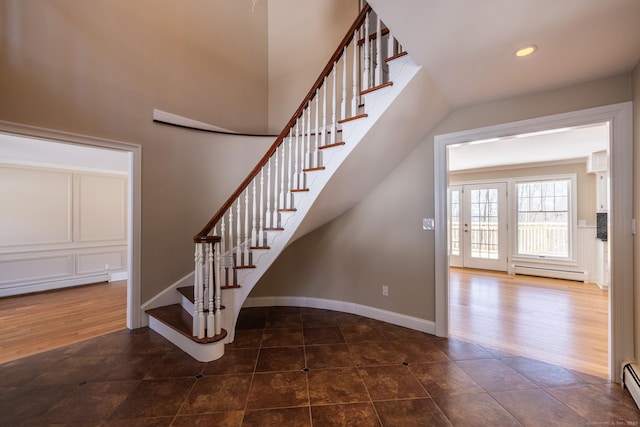 stairway featuring baseboard heating, recessed lighting, wood finished floors, and baseboards