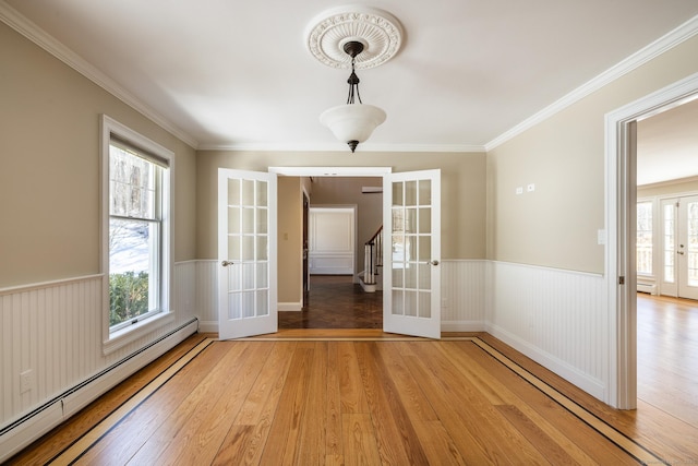 16 Saddle Ridge Rd, New Milford, CT 06776 - empty room with a baseboard radiator, a wealth of natural light, a wainscoted wall, french doors, and light wood finished floors