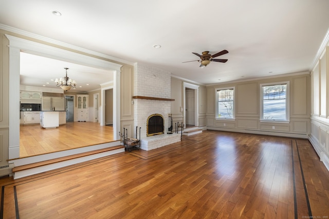 16 Saddle Ridge Rd, New Milford, CT 06776 - unfurnished living room featuring ceiling fan with notable chandelier, wood finished floors, and ornamental molding