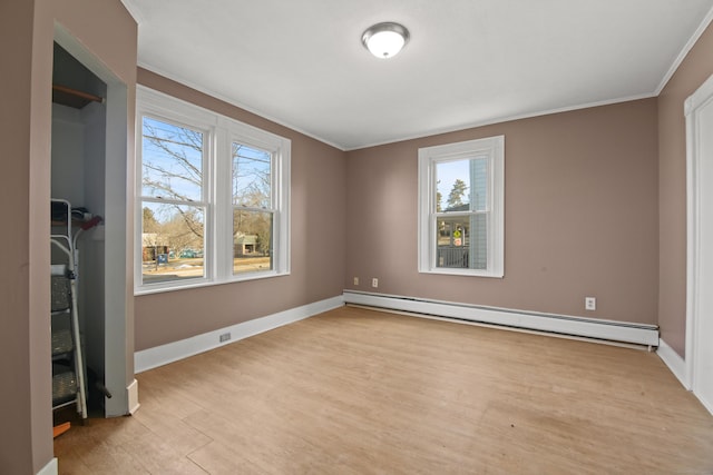 empty room with light wood-type flooring, ornamental molding, and baseboard heating