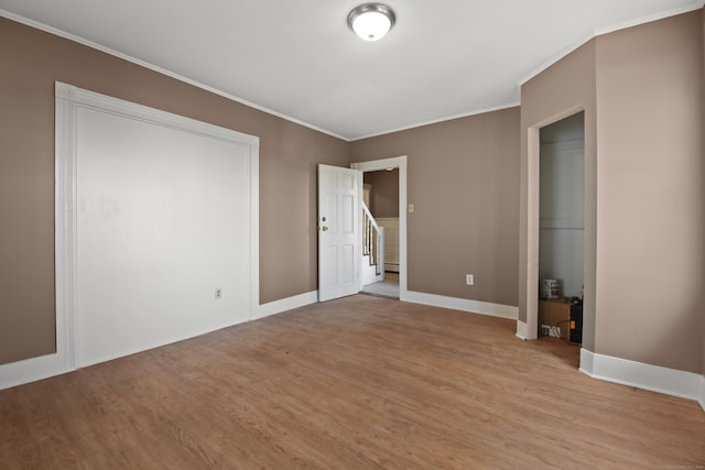 unfurnished bedroom with crown molding and light hardwood / wood-style floors