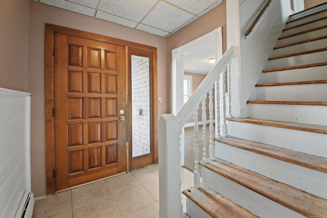 entryway with light tile patterned floors, a baseboard radiator, and a paneled ceiling