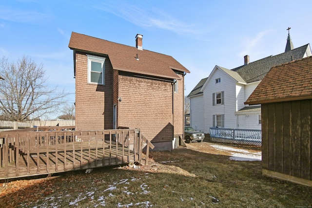 rear view of house with a yard and a deck