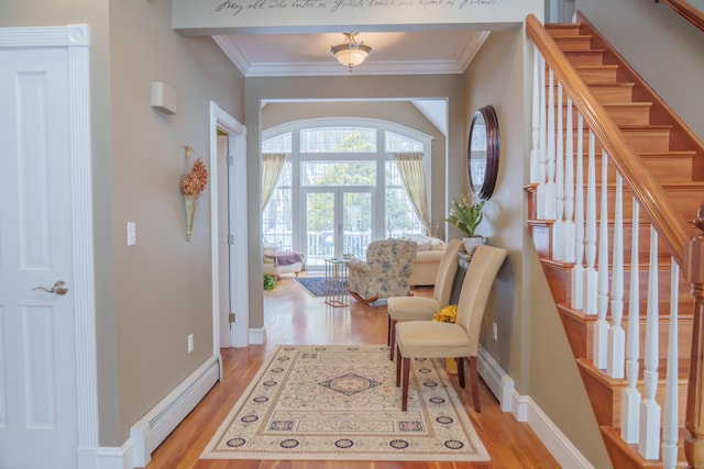 sitting room featuring baseboard heating, ornamental molding, and light hardwood / wood-style floors