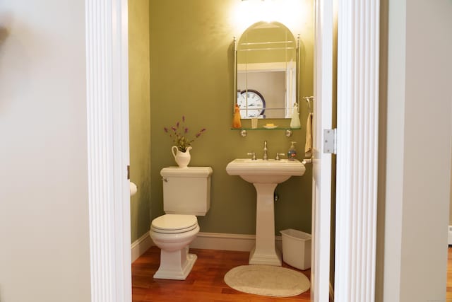 bathroom featuring hardwood / wood-style flooring and toilet