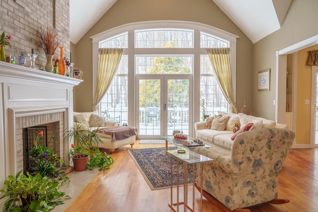 living room featuring a fireplace, wood-type flooring, and vaulted ceiling