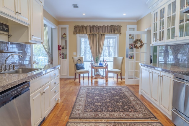 kitchen featuring white cabinetry, crown molding, dishwasher, and sink