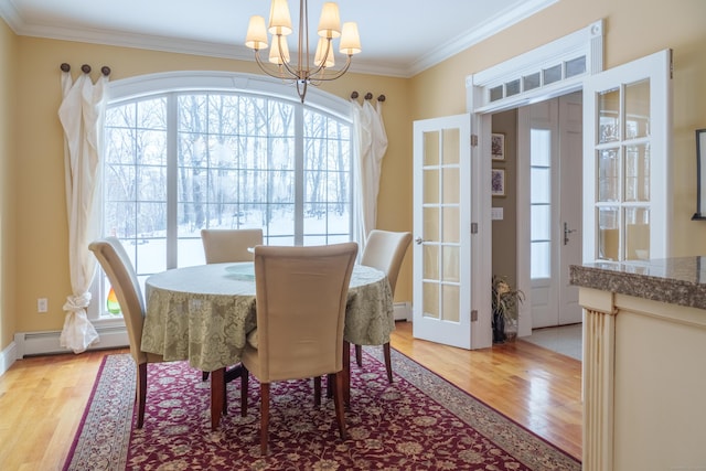 dining area with ornamental molding, a baseboard radiator, a chandelier, and light hardwood / wood-style flooring