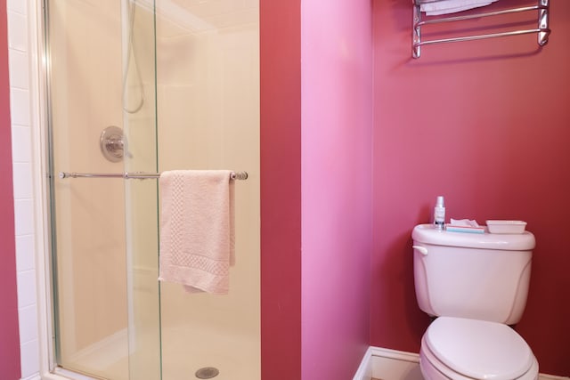 bathroom with toilet and a shower with shower door