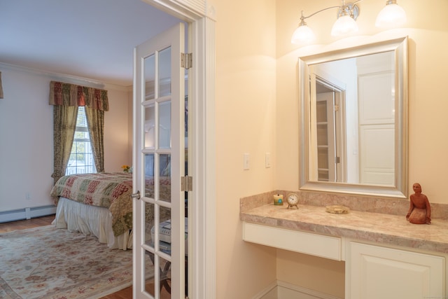 bathroom featuring crown molding, vanity, and a baseboard heating unit