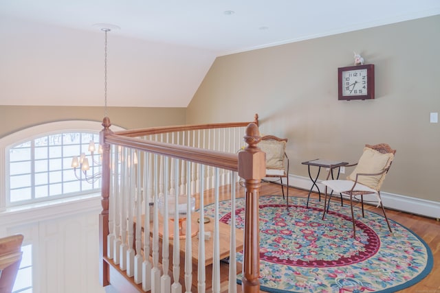 sitting room with an inviting chandelier, hardwood / wood-style flooring, and vaulted ceiling