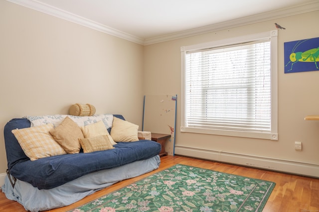 living area featuring hardwood / wood-style flooring, a baseboard radiator, and crown molding