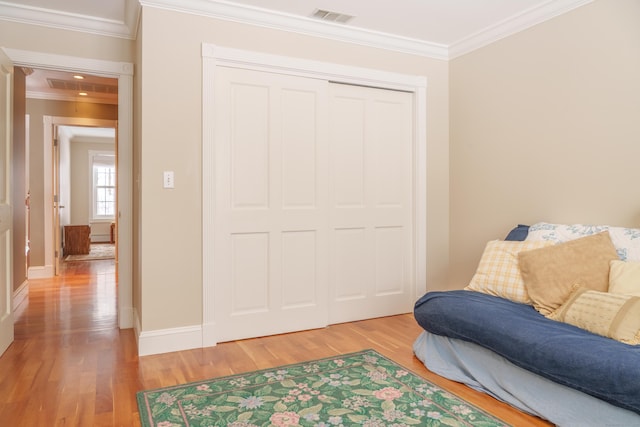 living area with hardwood / wood-style floors and ornamental molding