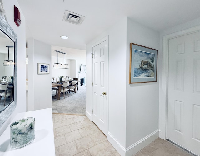 hallway with light colored carpet